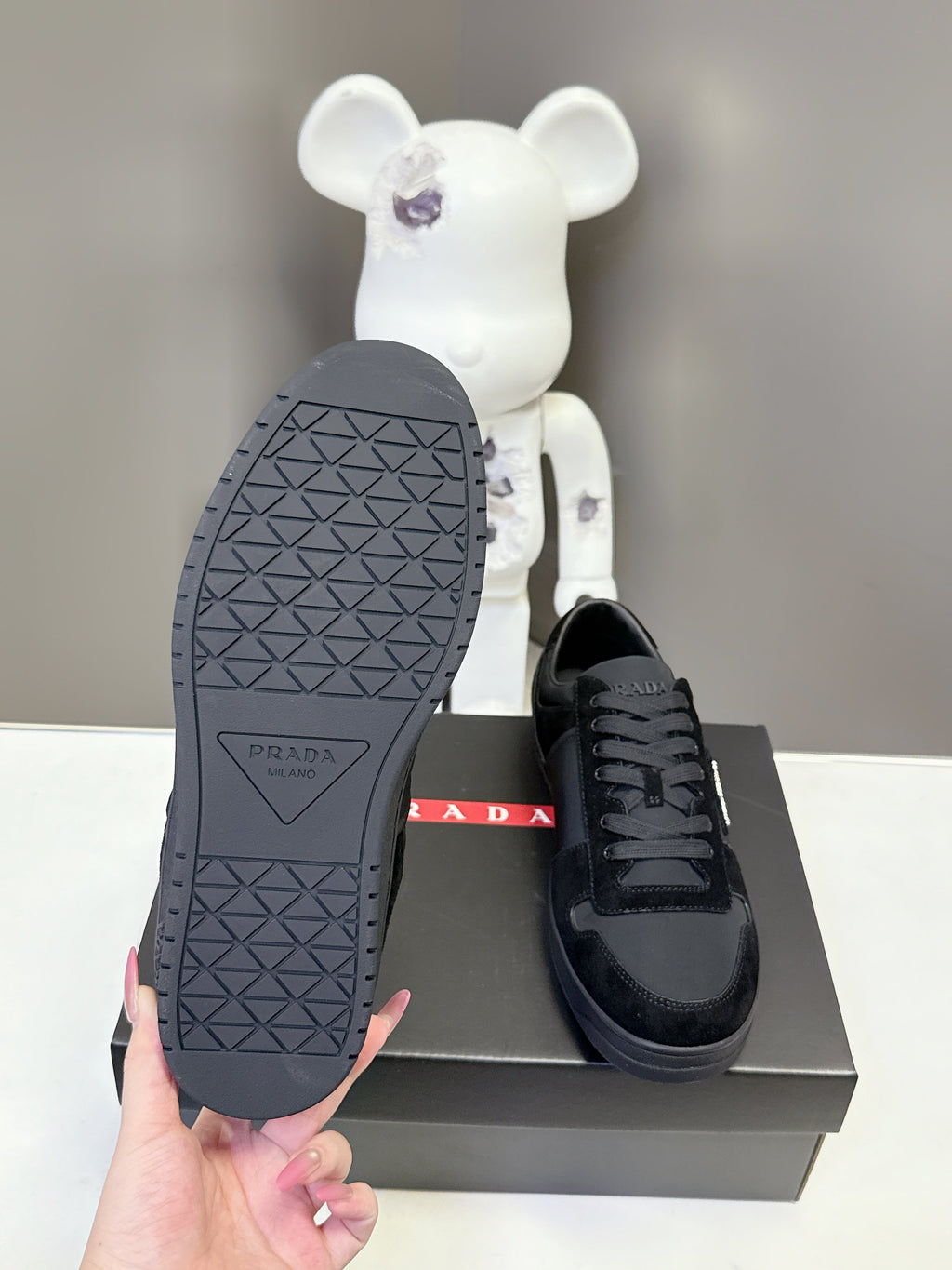 Black Prada unisex sneakers sole view with textured tread pattern on shoebox