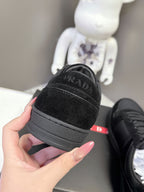 Black Prada unisex sneaker heel close-up with embossed PRADA branding on rubber sole