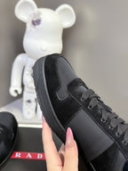 Black Prada unisex sneaker close-up on side, showing lace-up and textured toe cap