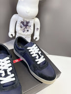Prada unisex sneakers close-up, navy suede with white laces and logo patch