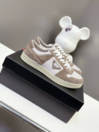 Unisex sneakers with suede taupe uppers, white logo, and white lace-up front