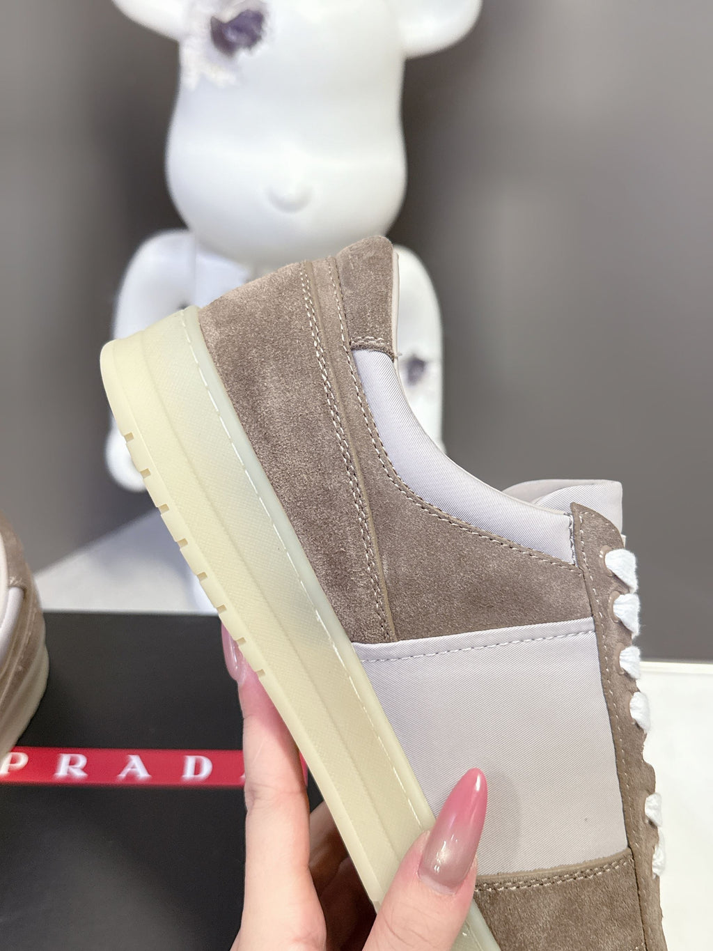 Side view of taupe suede sneaker with white laces and light yellow platform sole