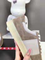 Side view of taupe suede sneaker with white laces and light yellow platform sole