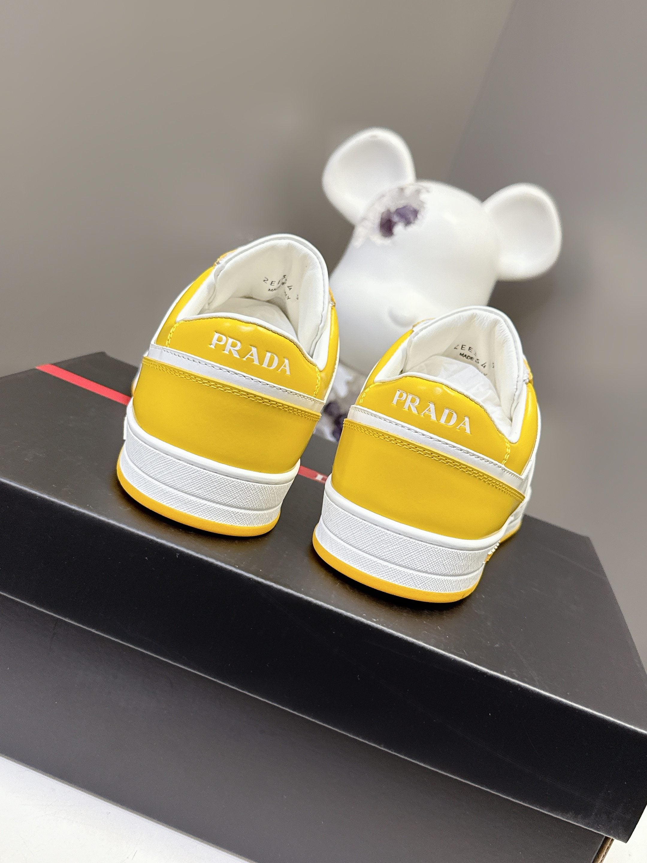 Prada unisex sneakers back view, yellow uppers with white heel and Prada branding
