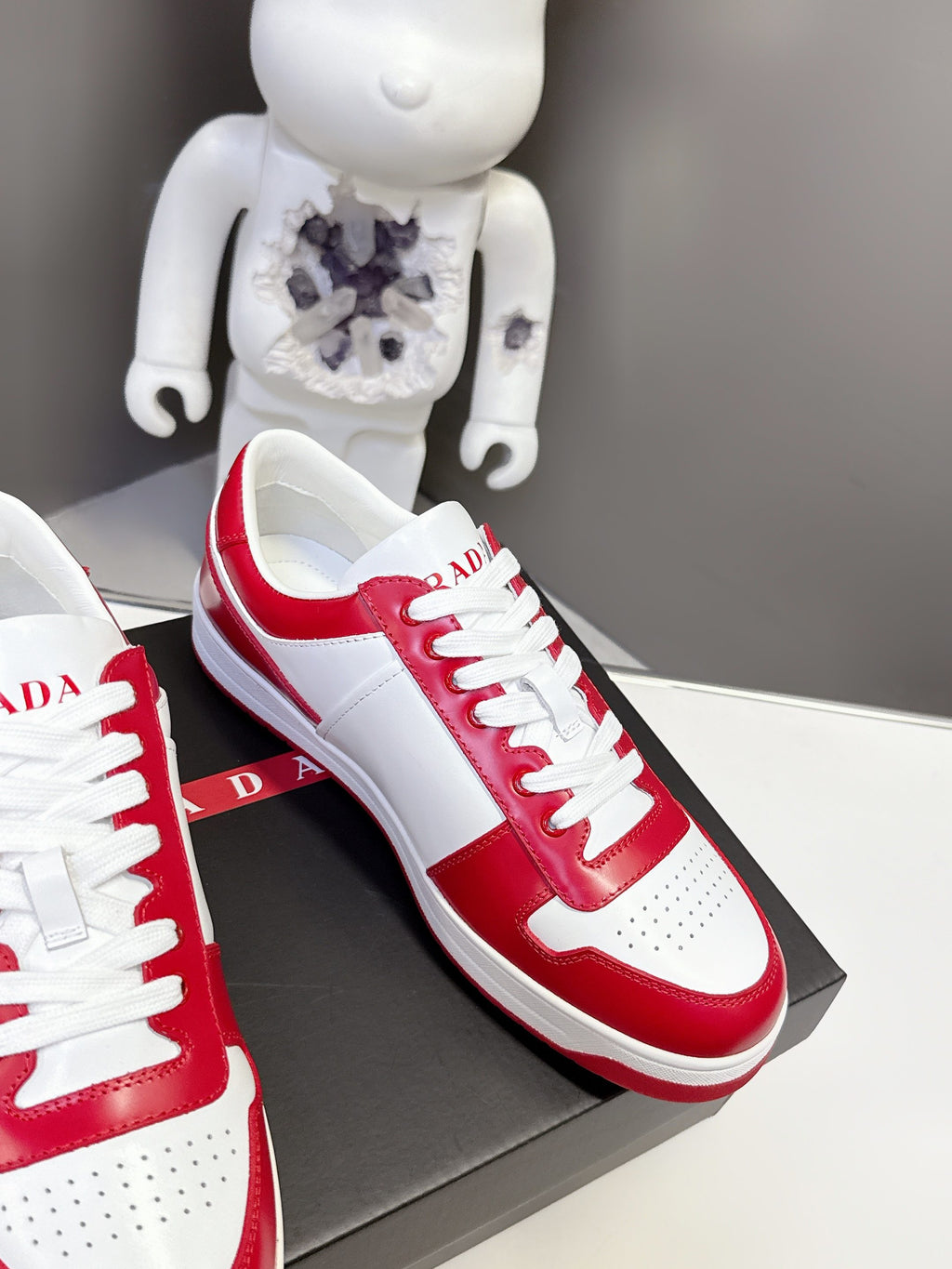 Red and white low-top sneakers in angled view with white laces