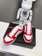 Red and white low-top sneakers with white laces and side logo badge