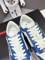 Blue and white Prada sneakers, close toe and tongue view with logo on tongue.