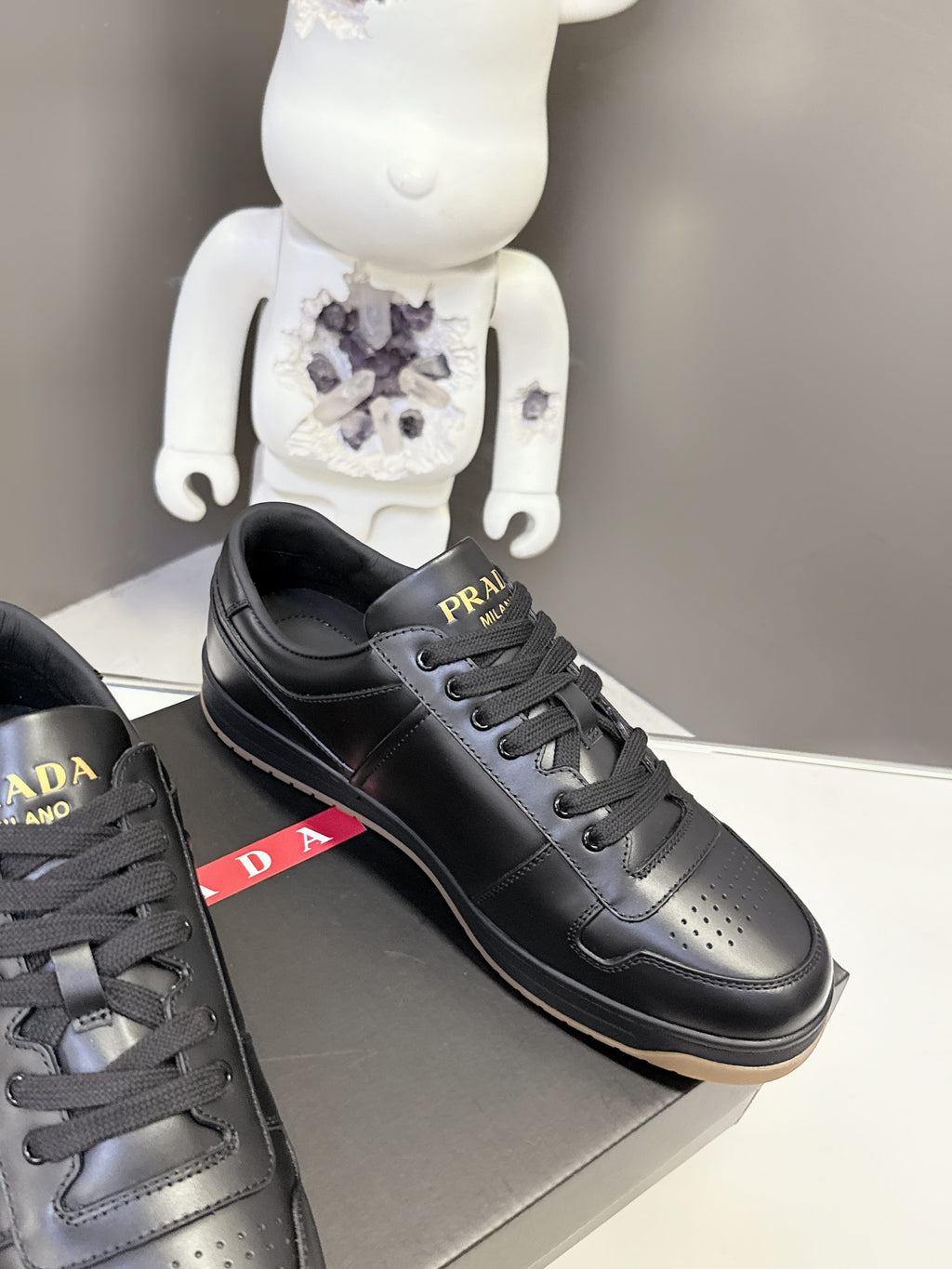 Prada black low-top sneakers with red PRADA side stripe and lace-up design