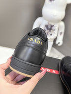Prada black sneakers close-up with gold PRADA logo on heel