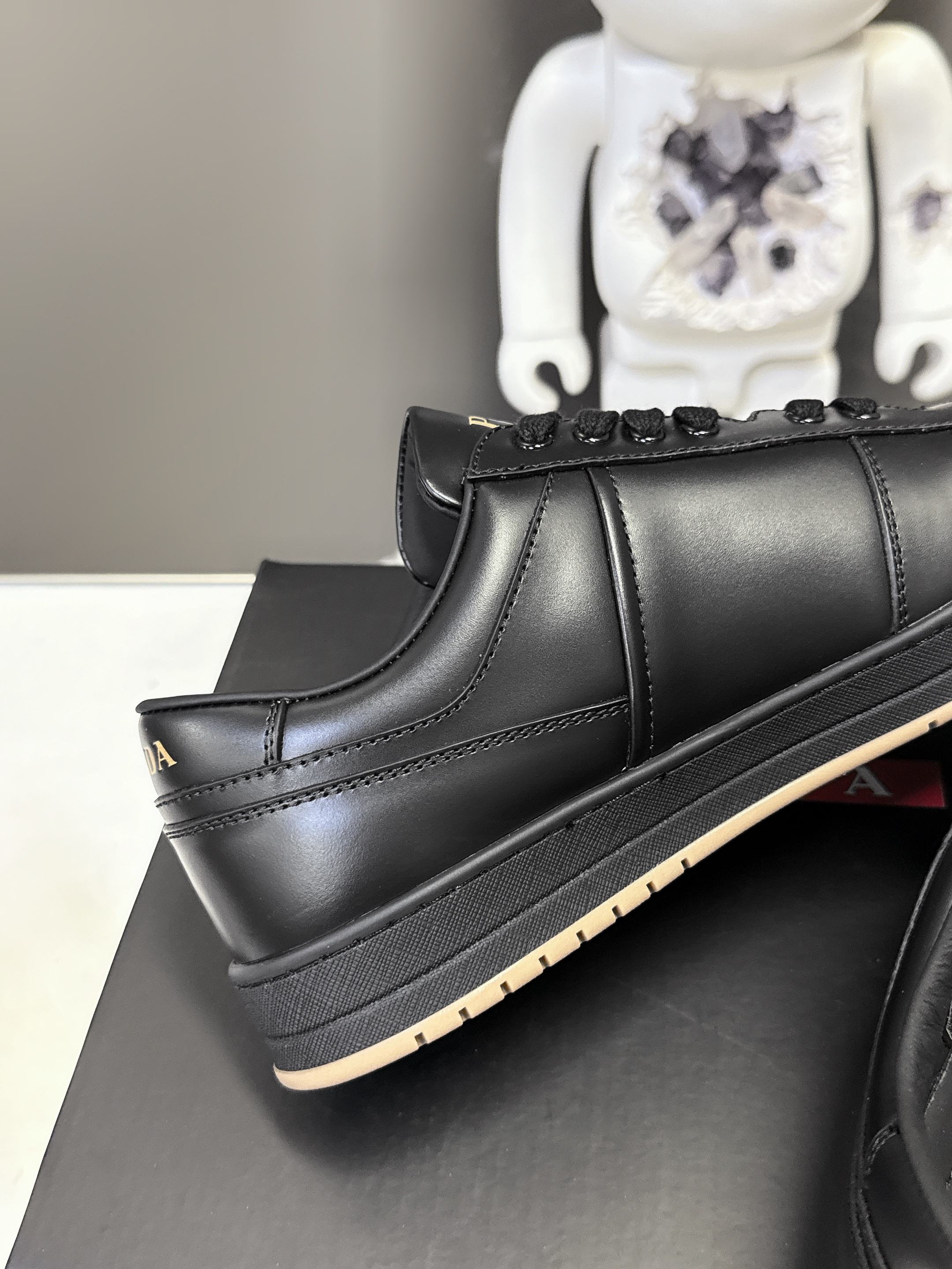 Prada black low-top sneakers with stitched side seam and dark rubber sole