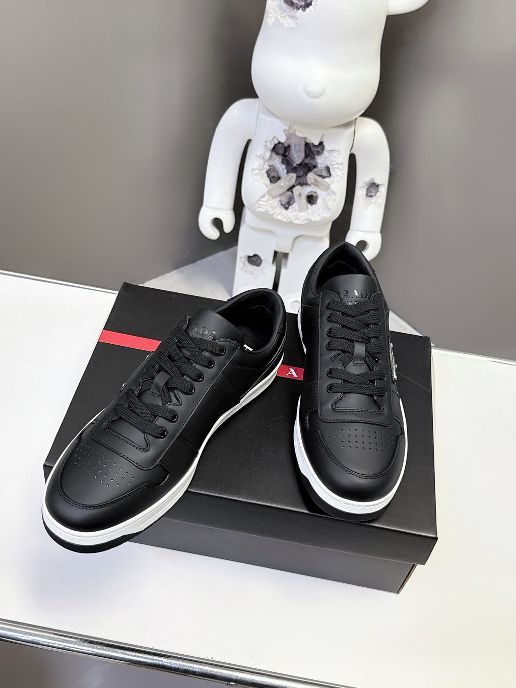 Black Prada unisex sneakers with white midsoles and lace-up closure