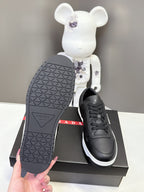 Black Prada unisex sneaker outsole and shoe on the box, showing tread pattern