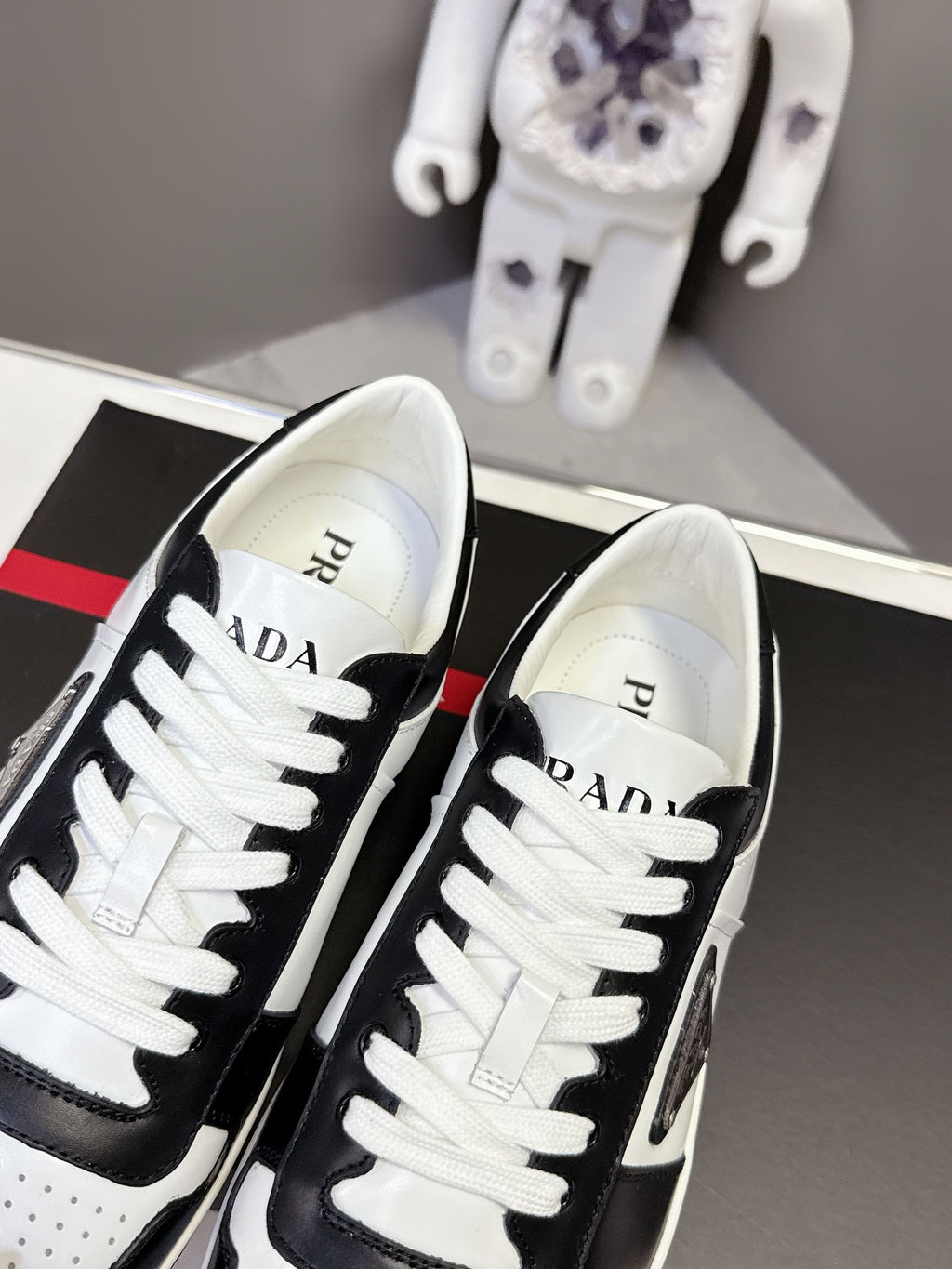 Prada unisex sneakers close-up, PRADA text on white tongue with black trim