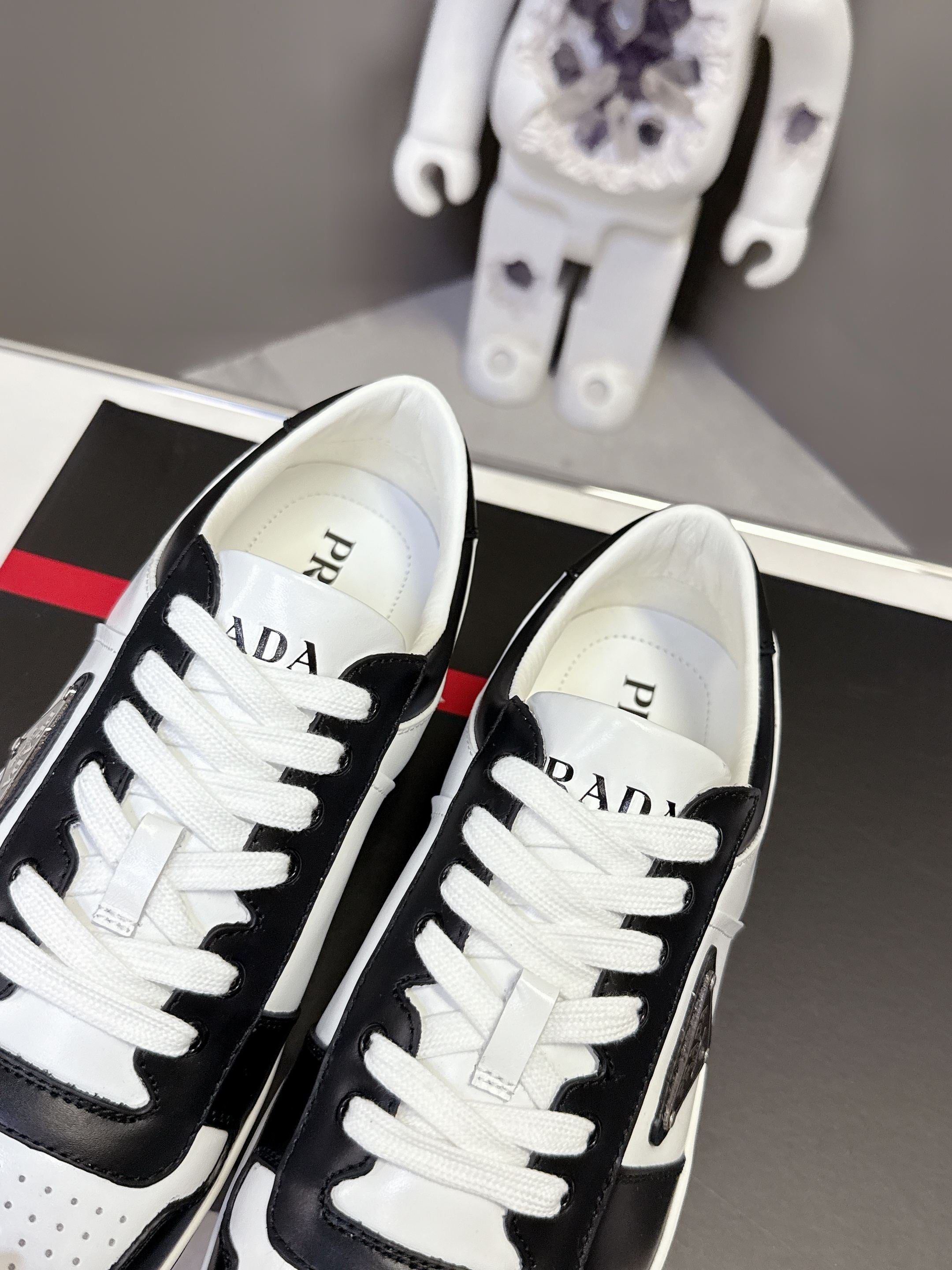 Prada unisex sneakers close-up, PRADA text on white tongue with black trim