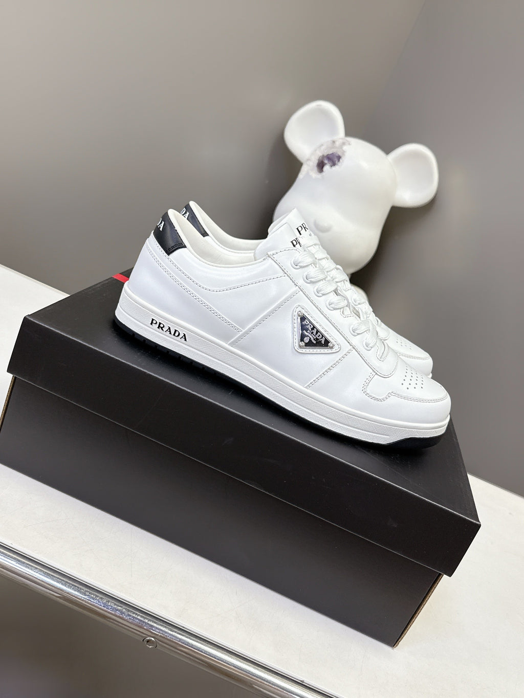 White Prada unisex low-top sneakers with lace-up front and side logo detail