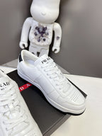 White Prada unisex sneakers side view with PRADA logo on the tongue