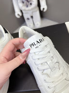 Close-up of white Prada unisex sneaker heel with PRADA logo on the back tab
