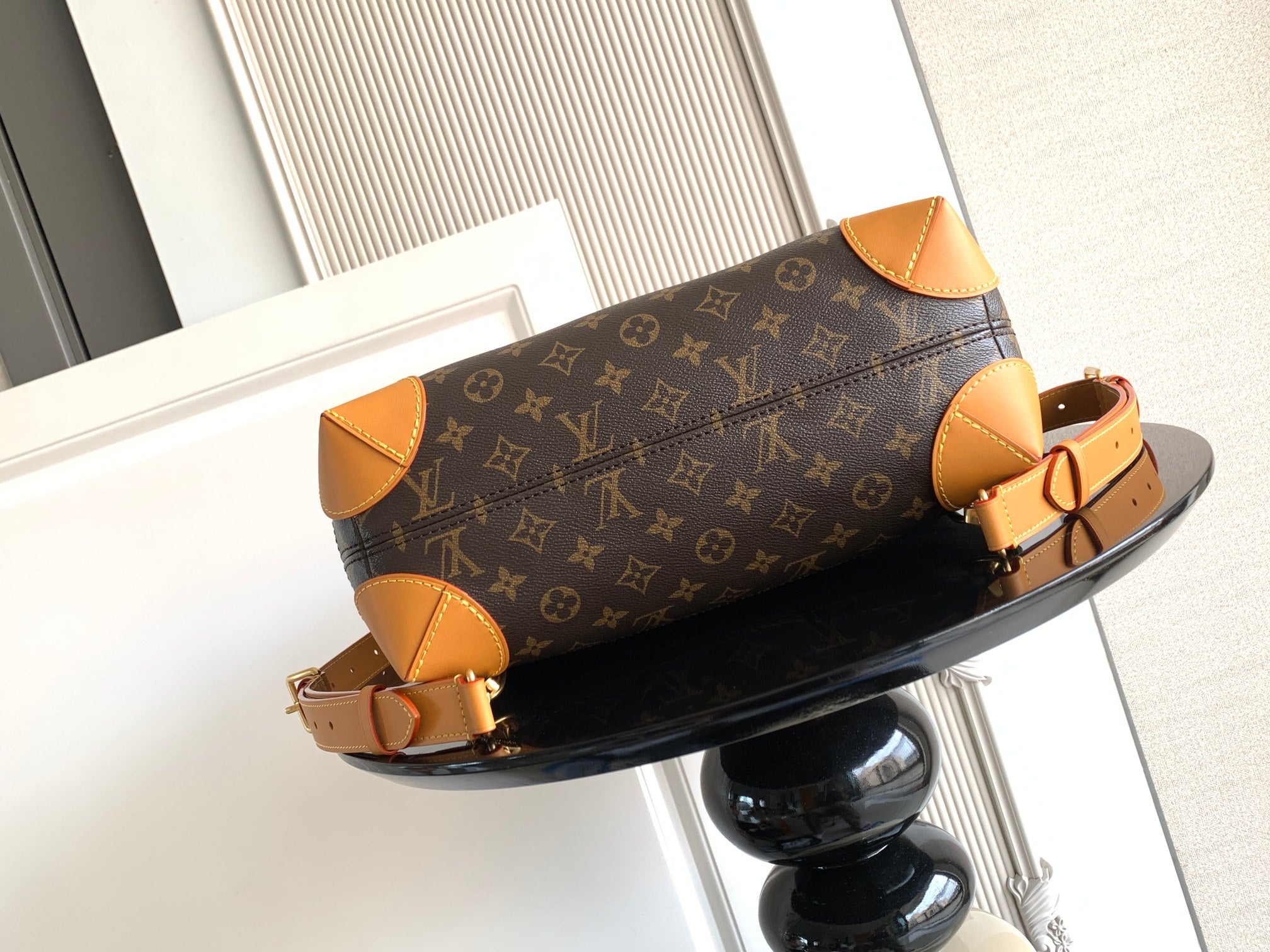 Louis Vuitton monogram handbag with tan leather shoulder strap and gold buckle details