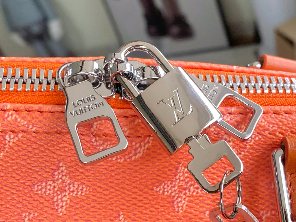Orange monogram bag front with polished metal lock clips and LV emblem