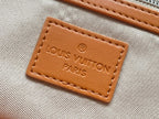 Tan fabric tag with Louis Vuitton Paris text stitched on orange monogram bag lining.