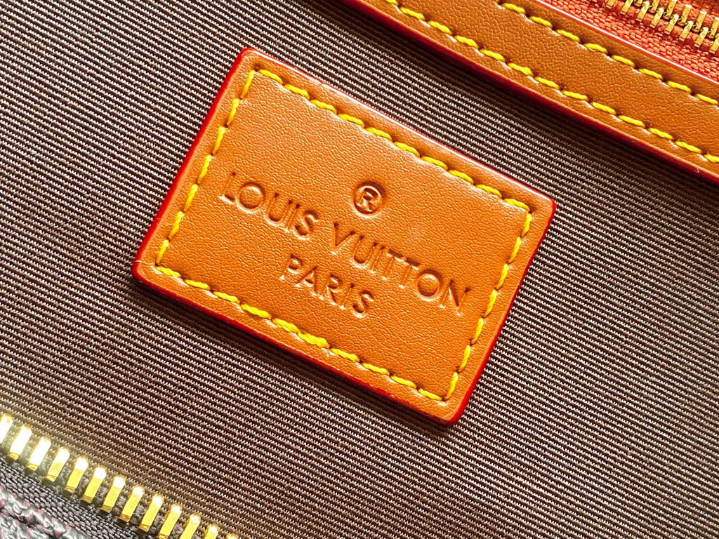 Louis Vuitton Paris embossed leather label on tan stitched trim