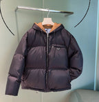 Prada hooded puffer jacket in dark color, full-zip front, logo patch on chest.
