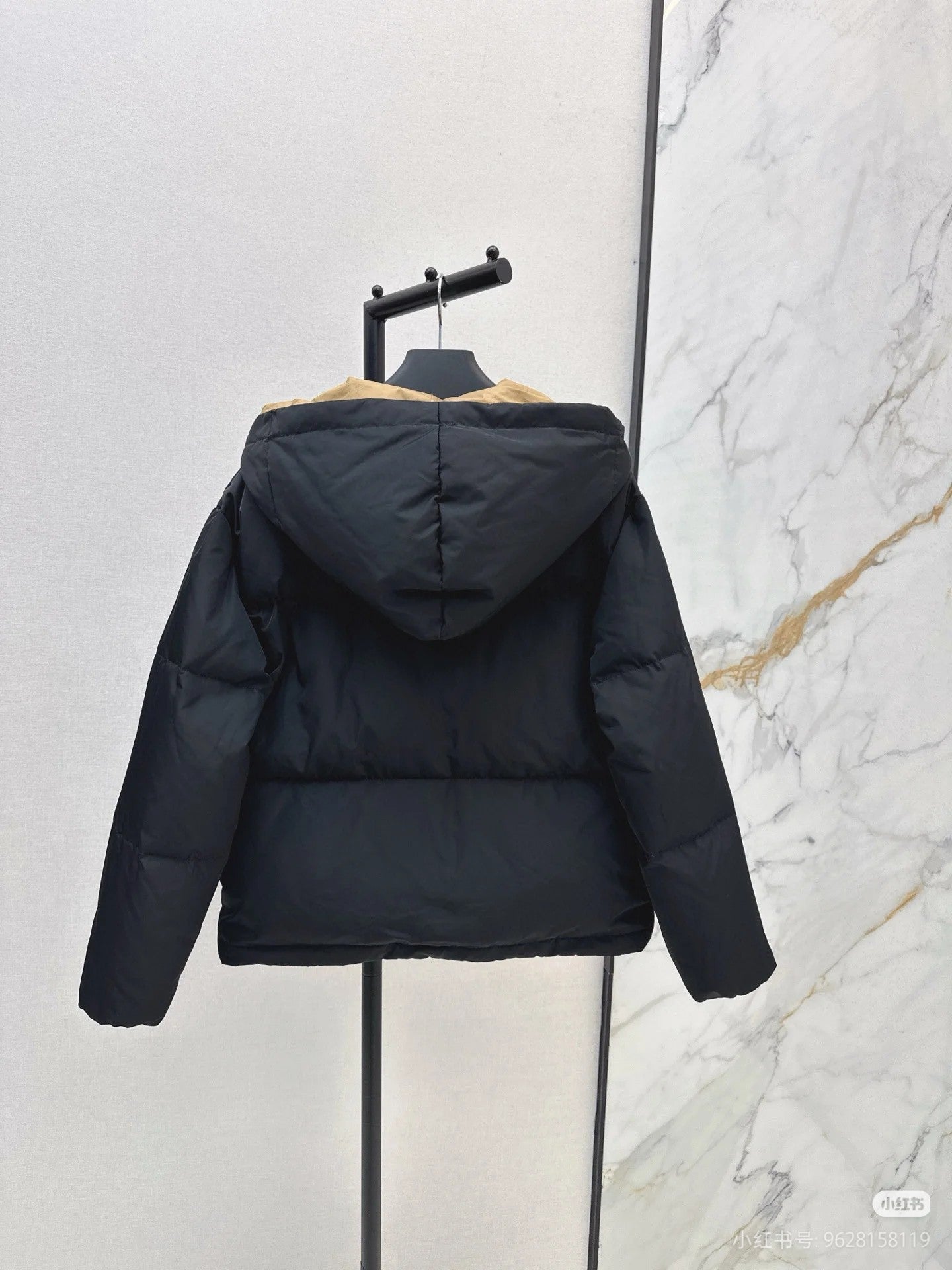 Prada hooded puffer jacket, dark color, back view with full sleeves and hood.