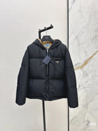 Prada hooded puffer jacket, dark color, full-zip front, chest logo patch.