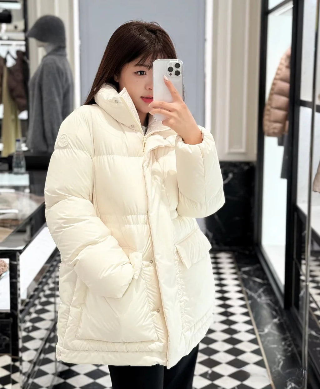 White Moncler hooded puffer jacket worn with black pants, quilted baffles