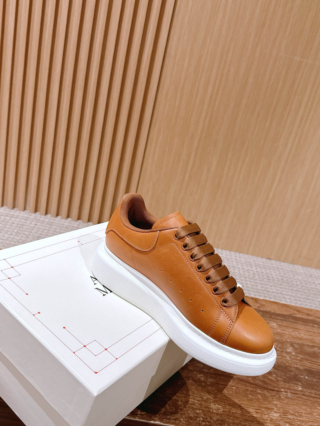 Tan leather low-top sneaker with lace-up front and white platform sole