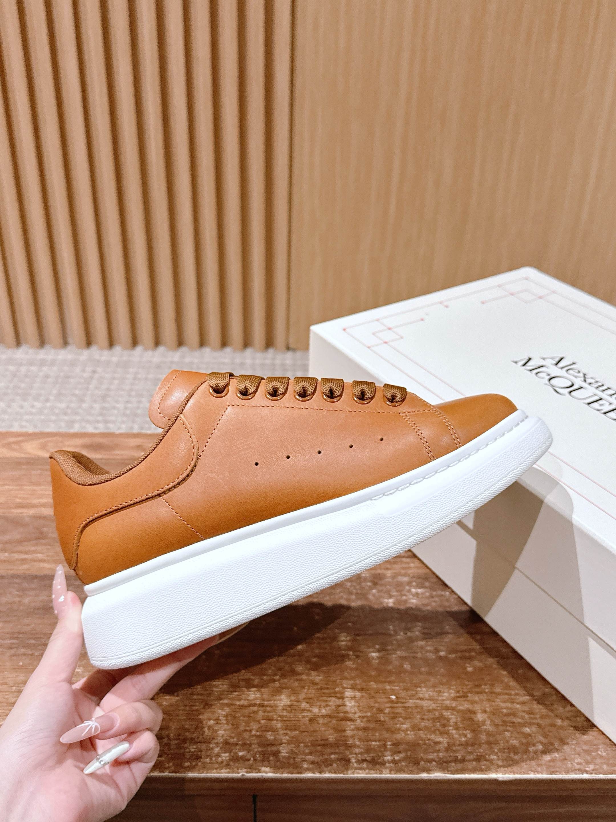 Tan leather low-top sneakers with white rubber sole and lace-up eyelets