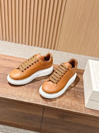 Tan leather low-top sneakers with perforated toe and white rubber sole