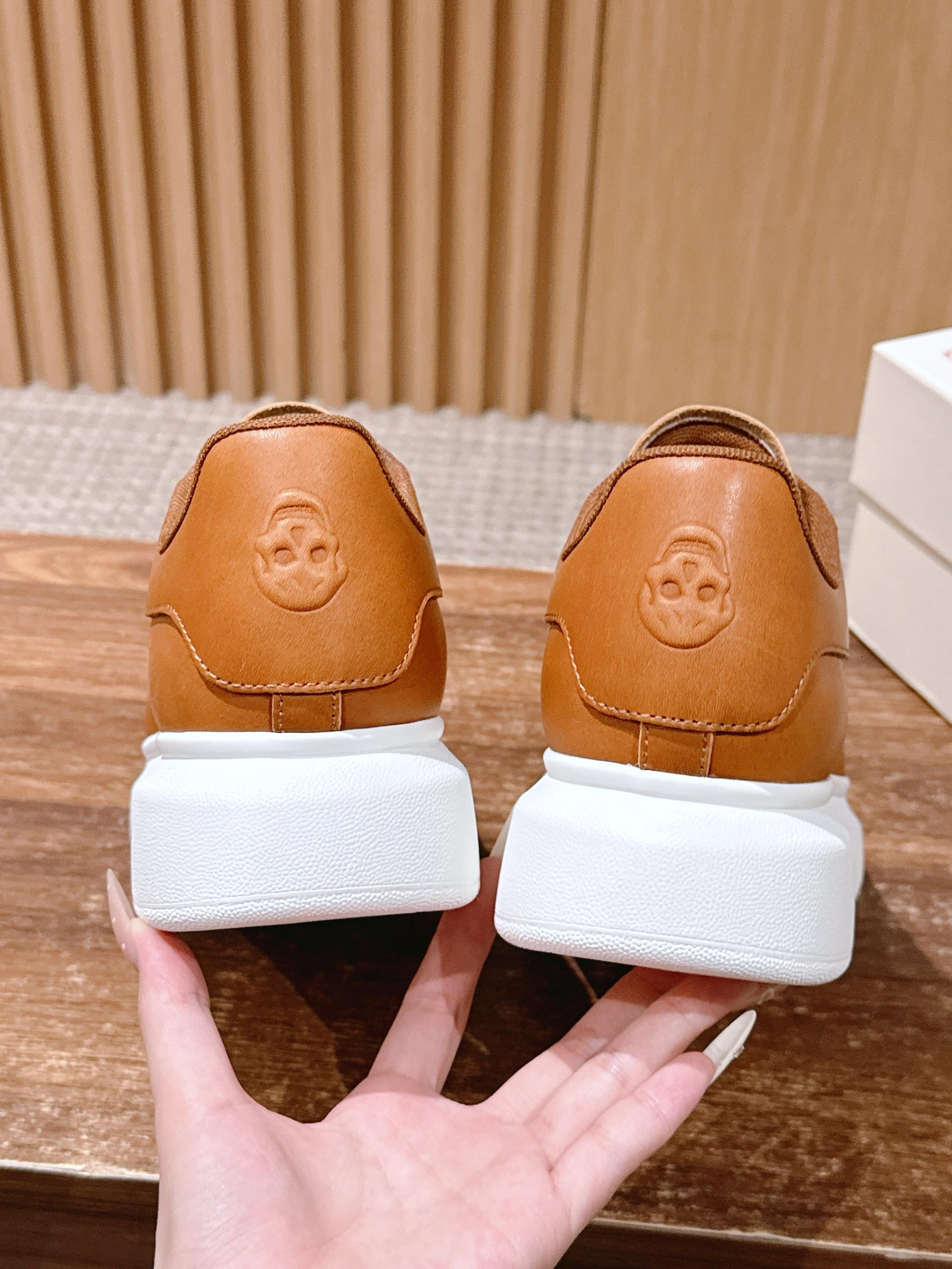 Tan leather sneakers with embossed heel logo and thick white midsoles