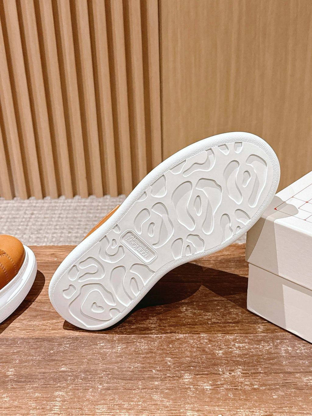 White outsole tread of tan leather low-top sneakers with grip pattern