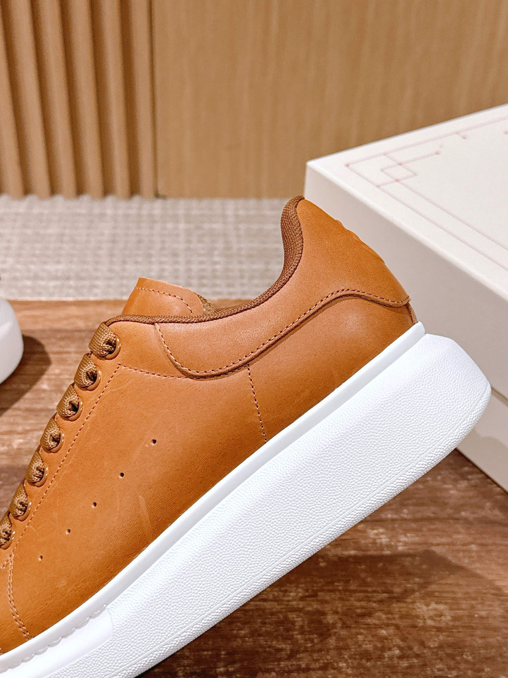 Tan leather sneakers with curved side panel, lace-up closure, white sole