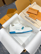 White Louis Vuitton trainer sneaker with blue sole and logo tab, open box.