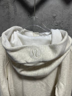 Cream hoodie with raised logo on the front of the hood