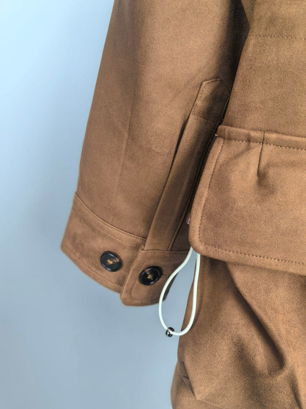 Brown suede-style jacket cuff with double buttons and hanging strap