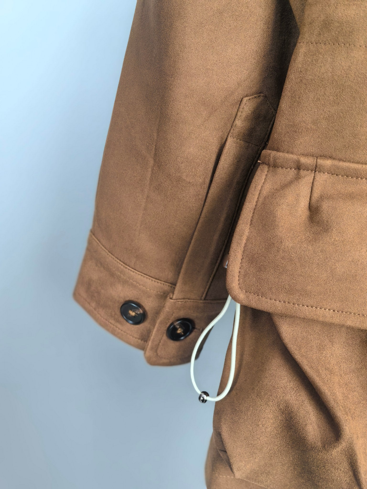 Brown suede-style jacket cuff with double buttons and hanging strap