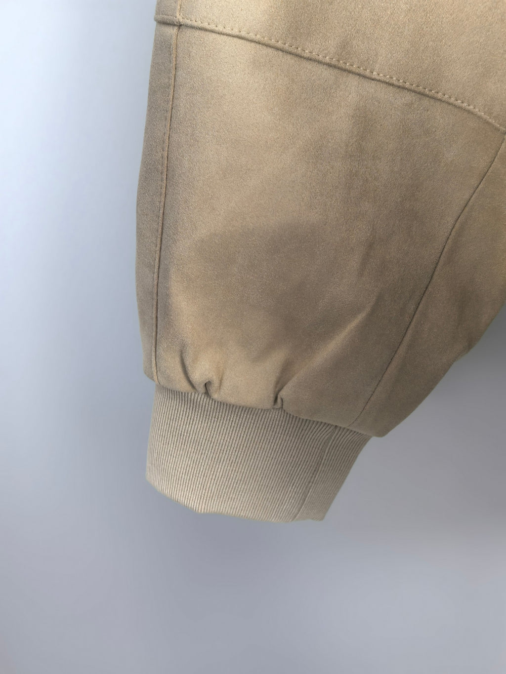 Tan jacket sleeve with ribbed cuff and curved shoulder seam