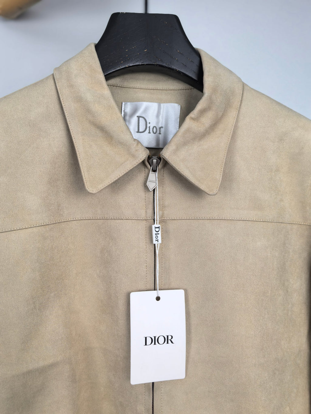 Tan jacket with point collar, front zipper, and Dior logo tag
