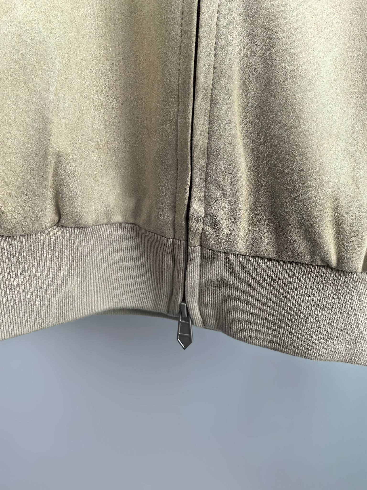 Tan jacket with center front zipper and ribbed lower band