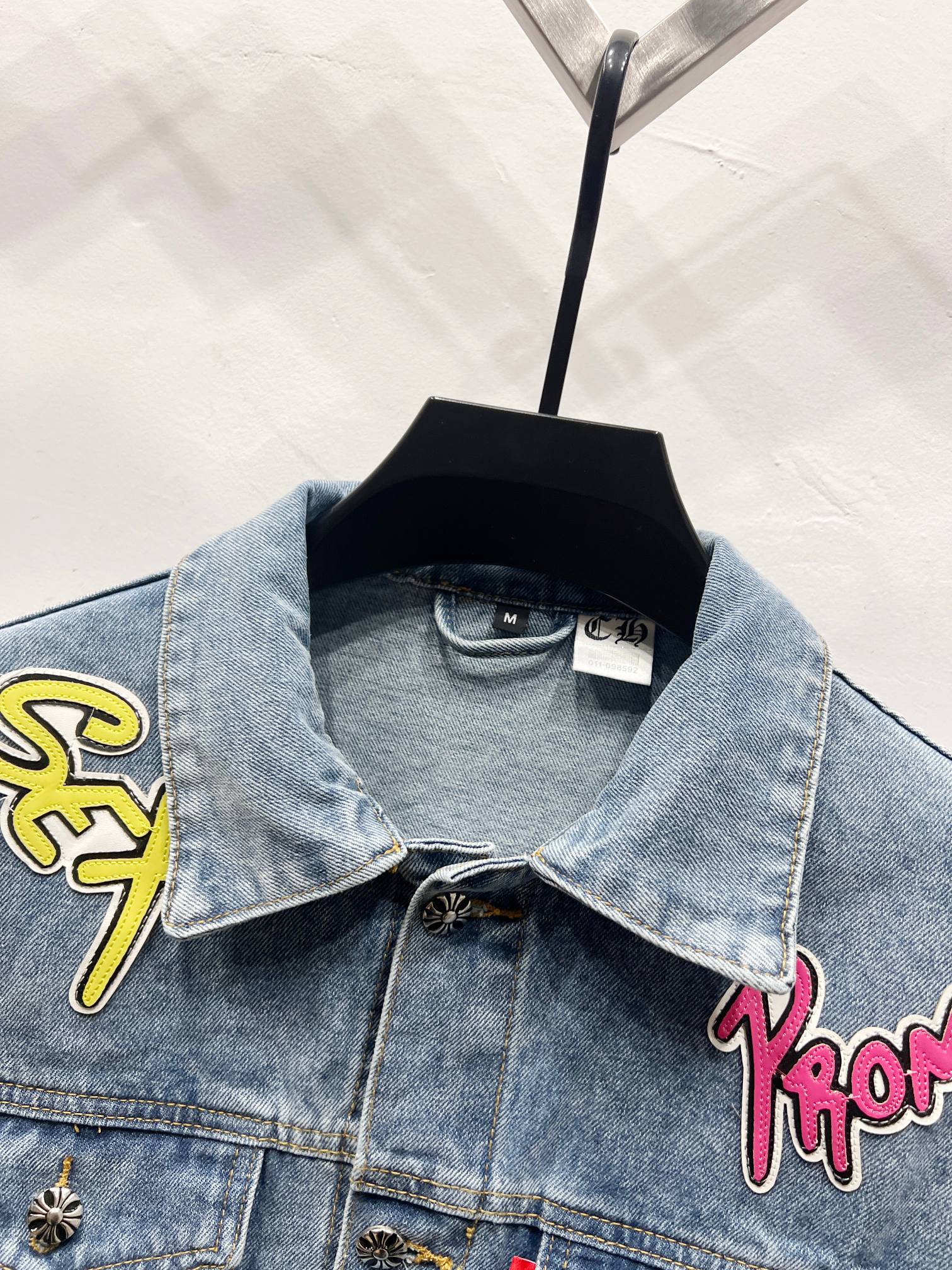 Light-wash denim jacket with pointed collar and patch embroidery on front shoulders