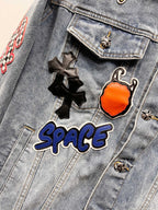 Light-wash denim jacket close-up of embroidered patches on a flap chest pocket