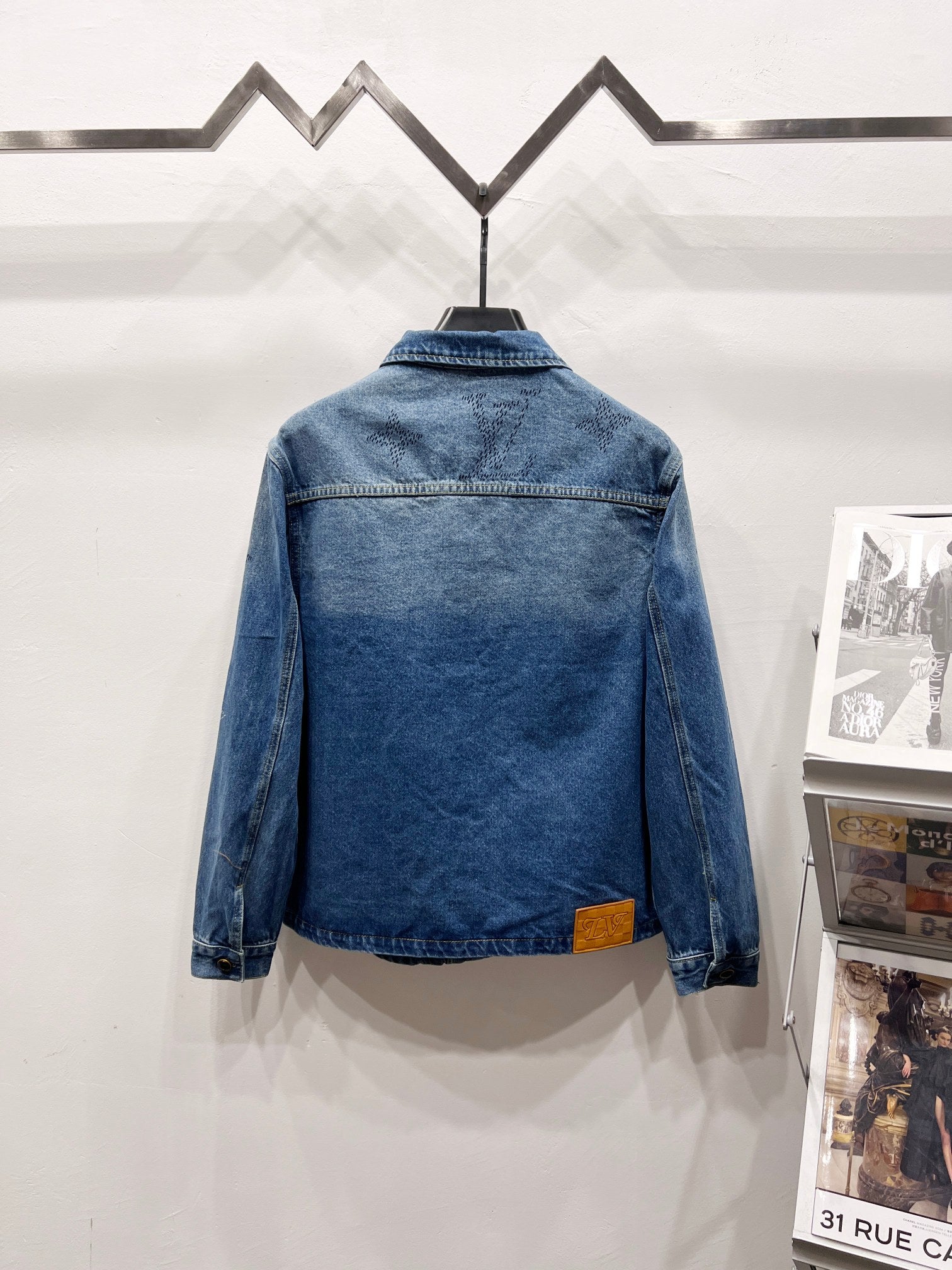 Light blue denim jacket back view with monogram pattern and button cuffs