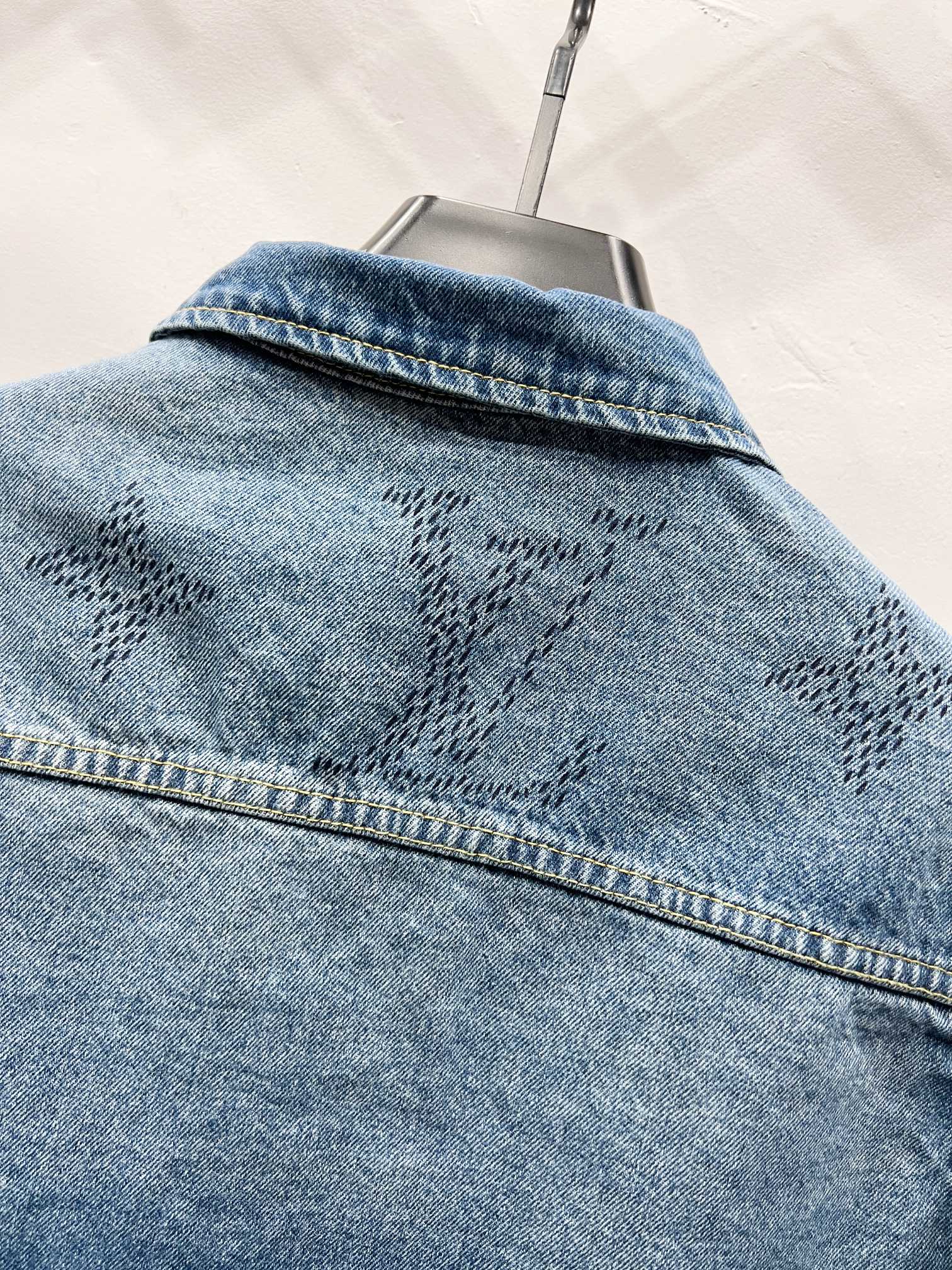Light blue denim jacket back yoke with monogram pattern and topstitched seam