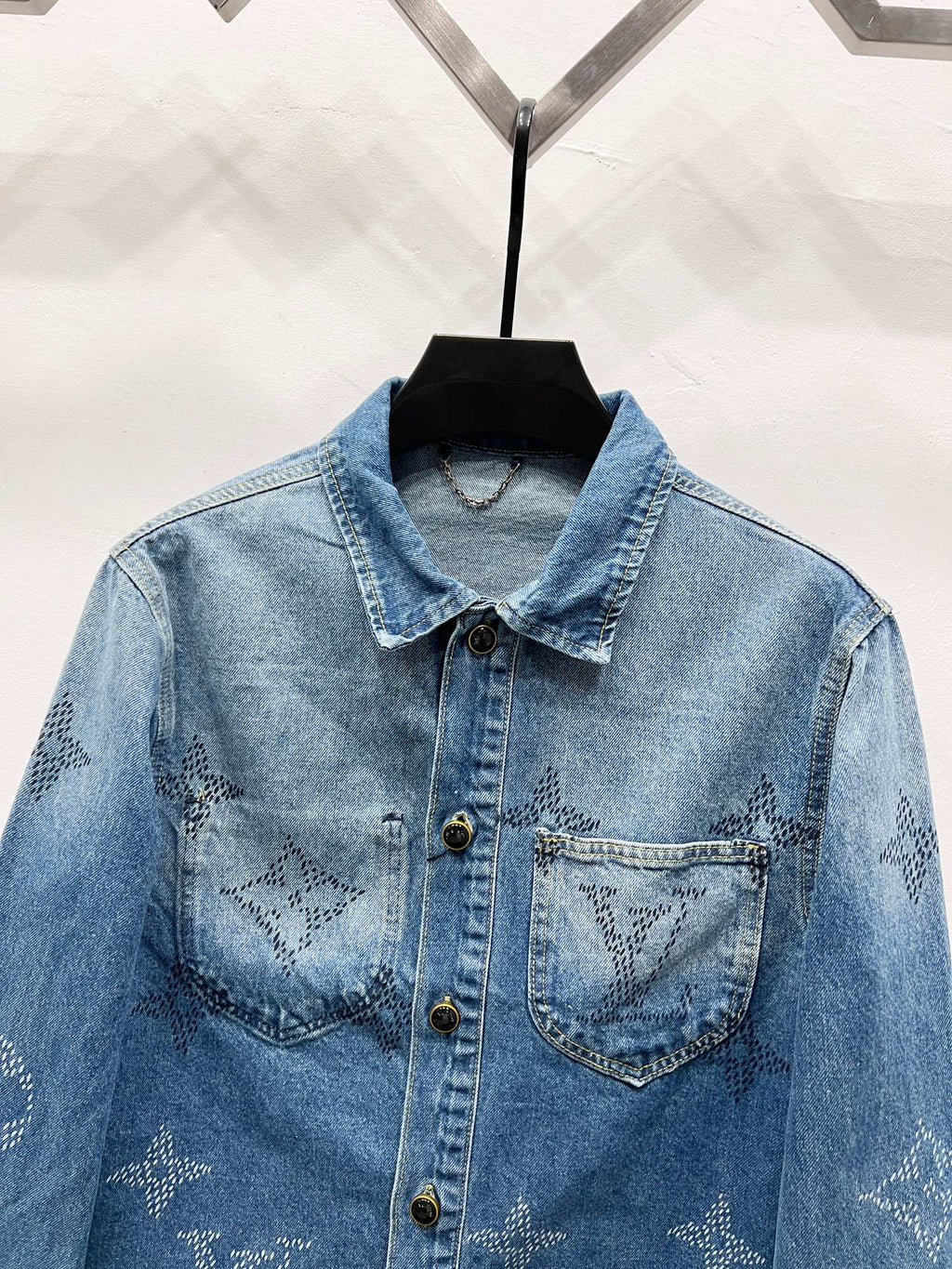 Light blue denim jacket with monogram chest panels, pointed collar and gold buttons