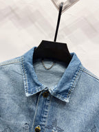 Light blue denim jacket front view with pointed collar, monogram print and button