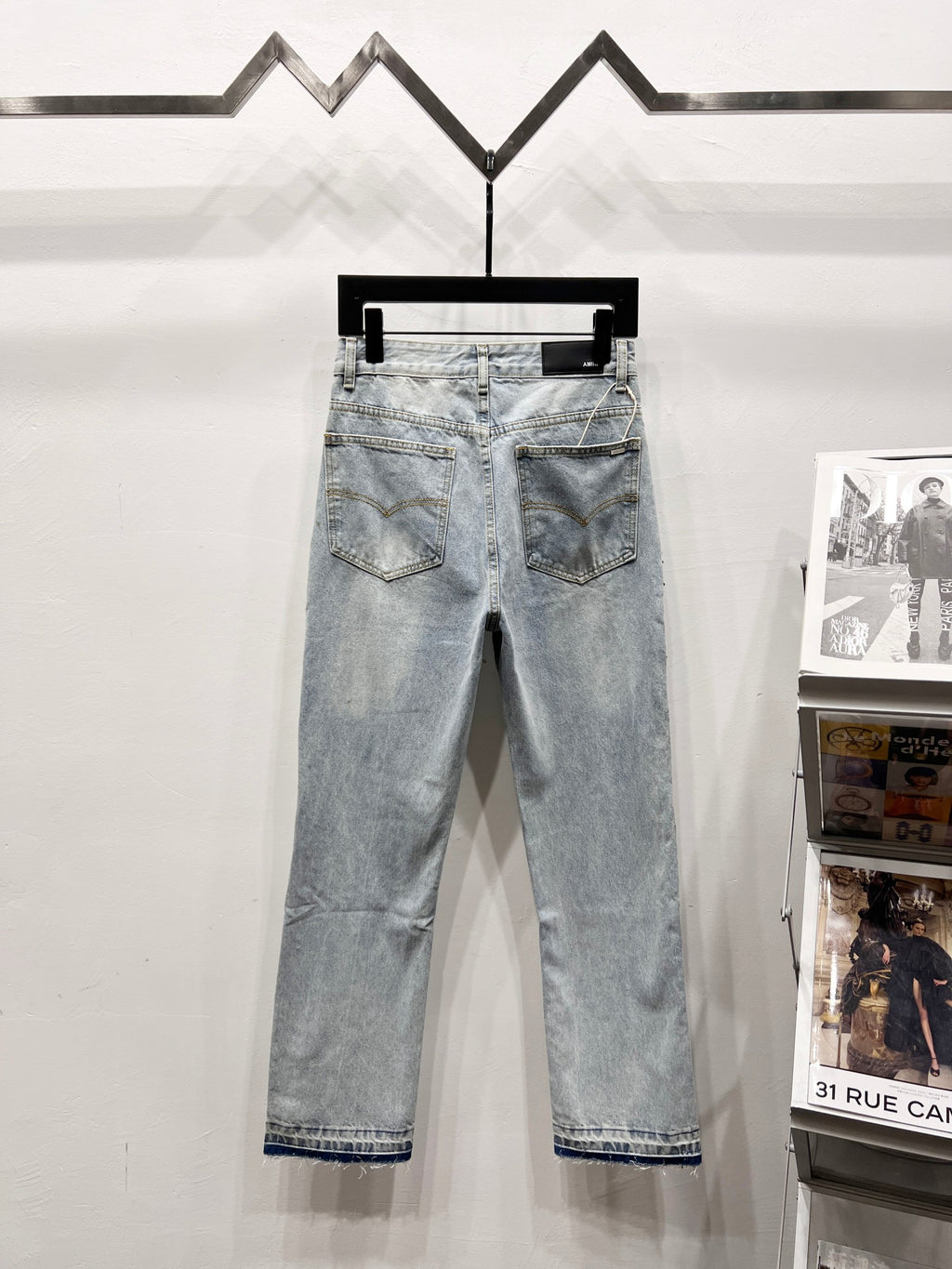 Light blue wash denim jeans with front pockets and rhinestone side embellishments