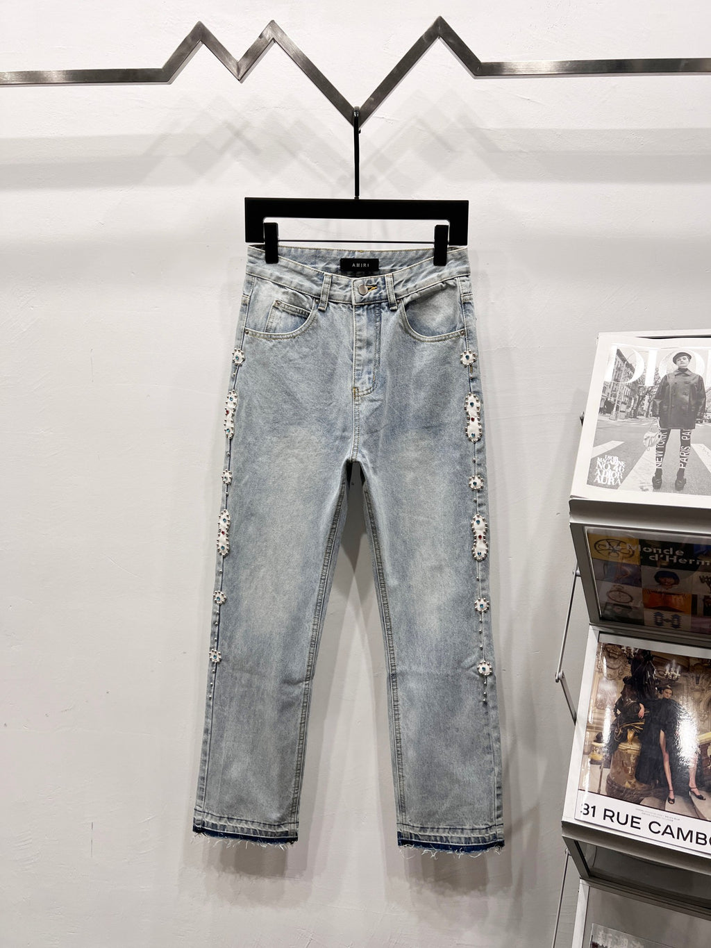 Light blue denim jeans with embellished side panels and cuffed hem